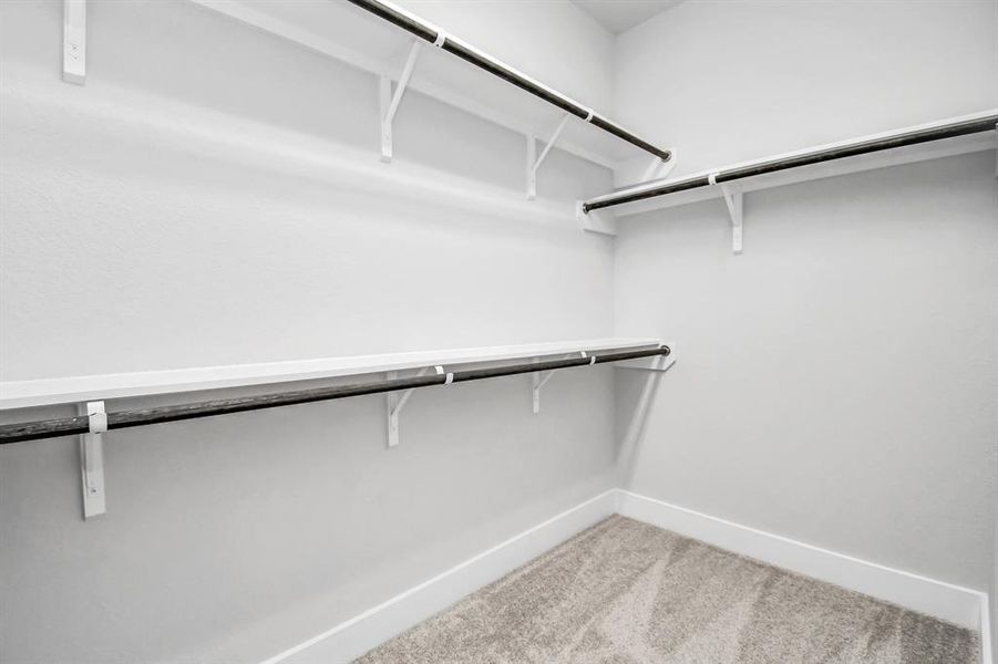 walk-in closet that epitomizes luxury and practicality. This generously sized space features built-in shelving, offering abundant room for impeccable organization. High ceilings and recessed lighting create a bright and welcoming ambiance.