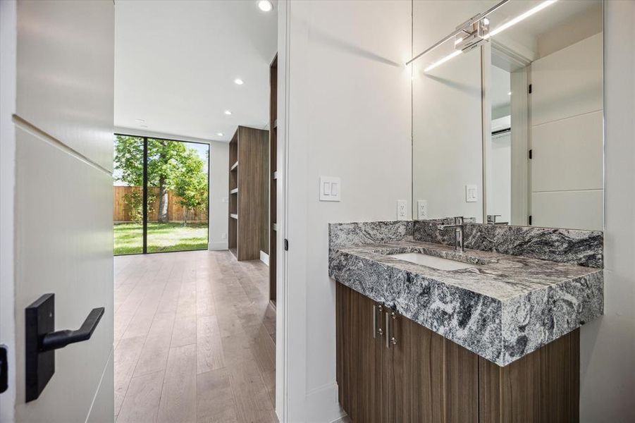 The gym is equipped with a half bathroom featuring Viscon White countertops and Sensei White Lithos floor tile. It includes a Grohe single-hole bathroom sink faucet in polished chrome, a Kohler undermount bathroom sink, and a Duravit one-piece toilet for added convenience and functionality.