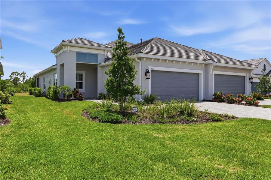 Front exterior of a new home in Windward, Lakewood Ranch, FL, highlighting curb appeal (Image 1). Front exterior of a new home in Windward, Lakewood Ranch, FL, highlighting curb appeal (Image 1).