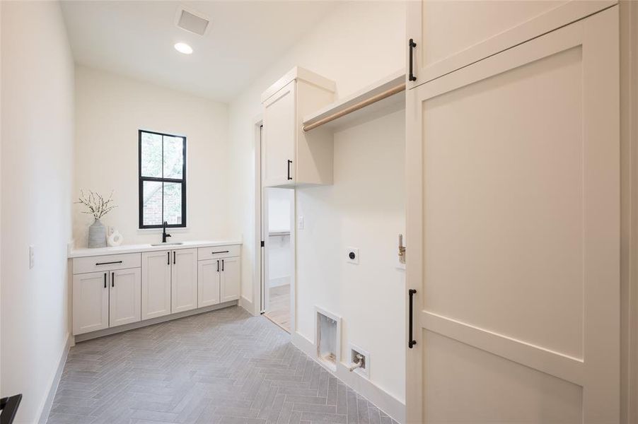 The larger of the two laundry rooms is attached to the primary closet.