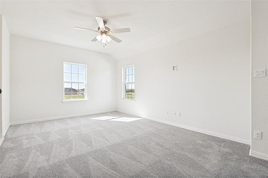 Empty room with light carpet, lofted ceiling, and ceiling fan