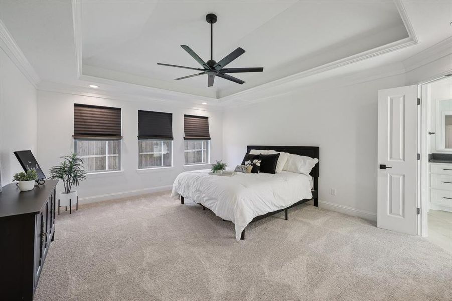 Bedroom featuring ornamental molding, light carpet, a ceiling fan, a raised ceiling, and recessed lighting Bedroom featuring ornamental molding, light carpet, a ceiling fan, a raised ceiling, and recessed lighting