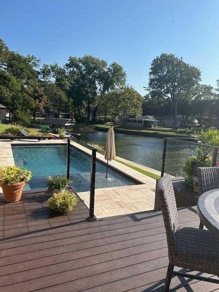 Outdoor pool featuring a deck with water view
