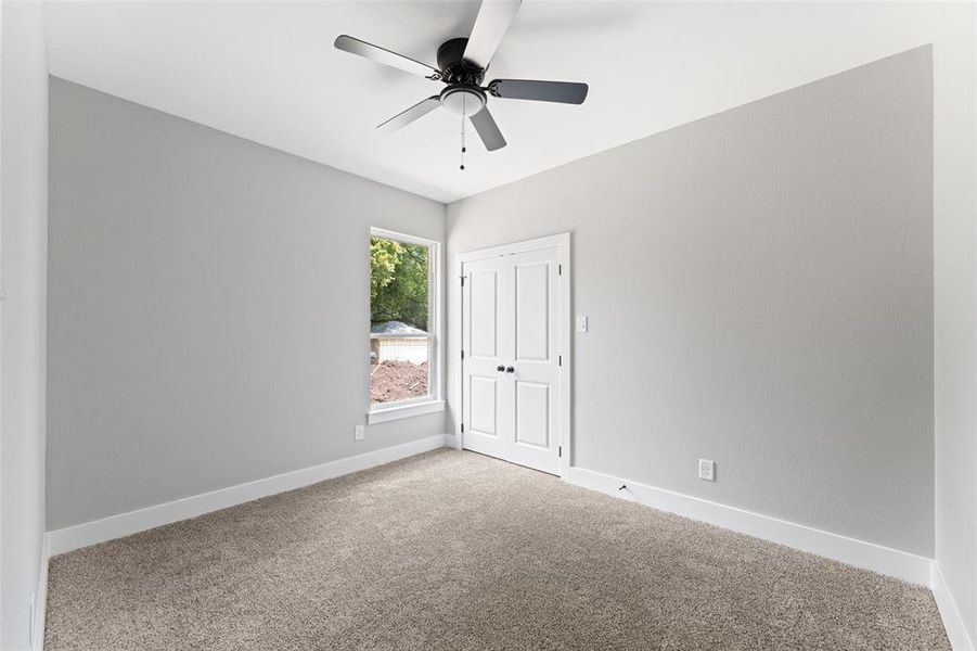 Unfurnished bedroom with carpet flooring, ceiling fan, and a closet