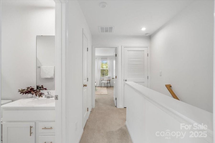 Upper level hallway. The laundry is at the top of the stairs. Another custom linen closet is in the hall.