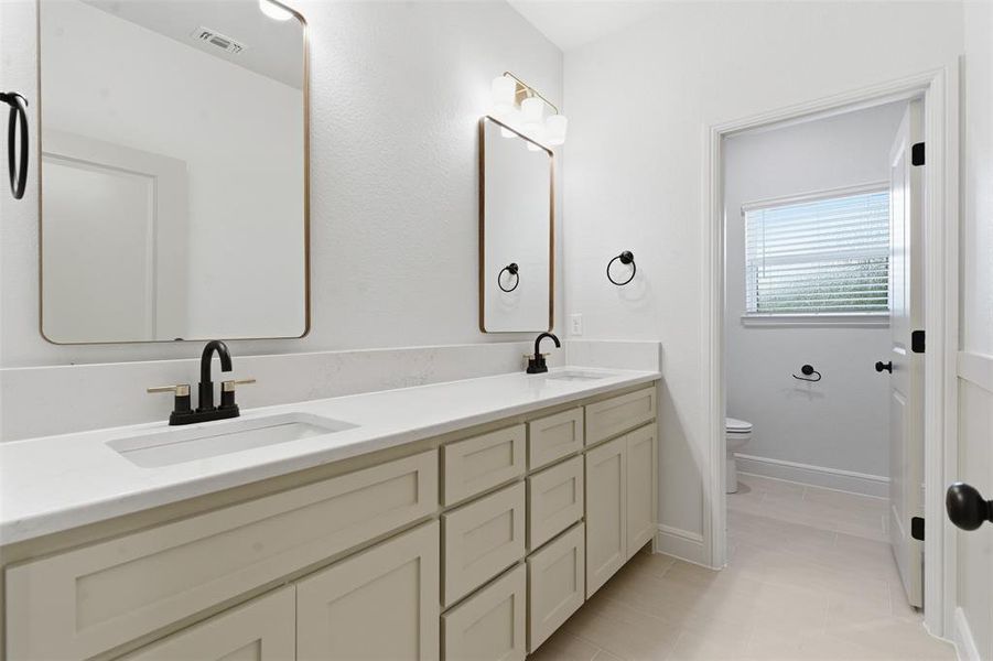 Bathroom featuring double vanity and light tile patterned flooring Bathroom featuring double vanity and light tile patterned flooring