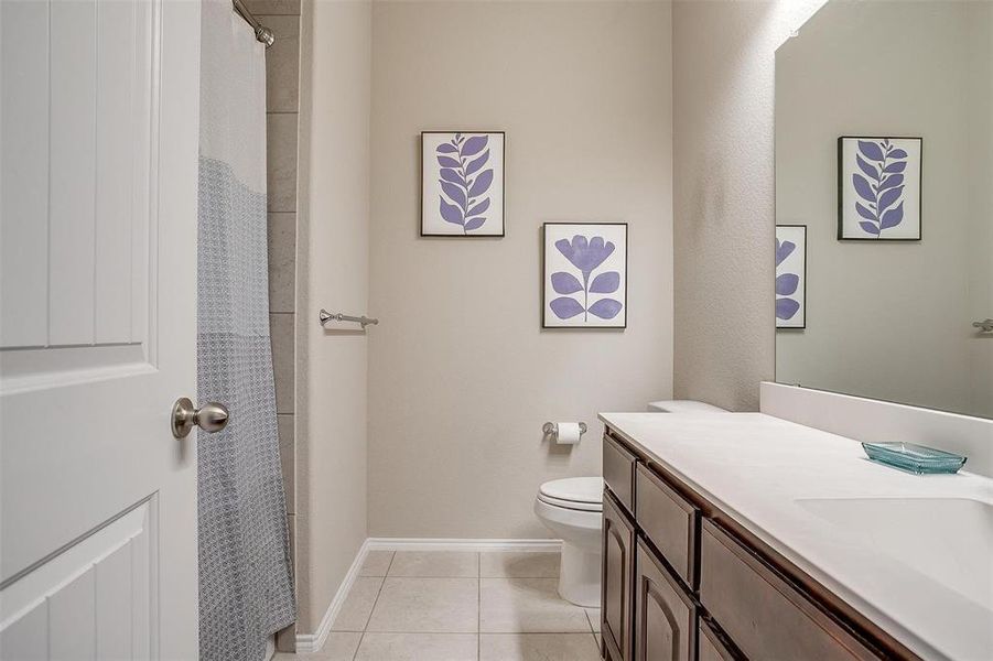 Bathroom with toilet, vanity, and tile patterned floors