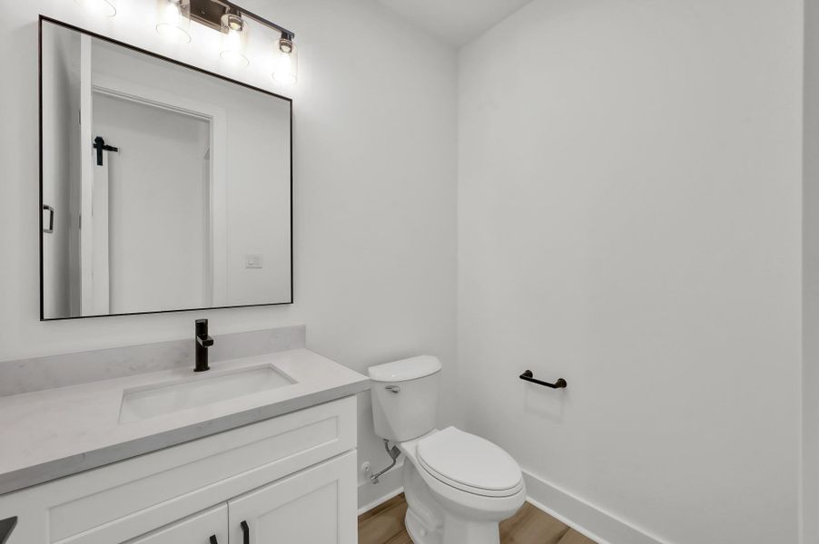 Convenient powder bath with sleek quartz vanity, modern fixtures, and clean contemporary finishes.