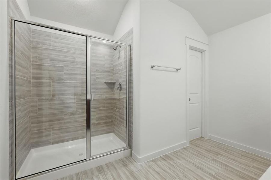 Bathroom with a shower stall and light wood-type flooring