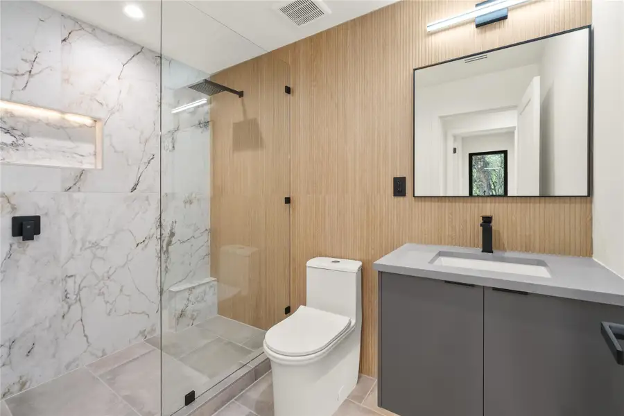 Full bath featuring  a marble finish shower, and vanity