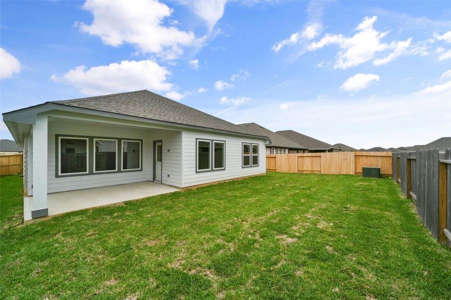 Modern single-story home featuring a spacious fenced backyard, covered patio, and large windows that fill the space with natural light.