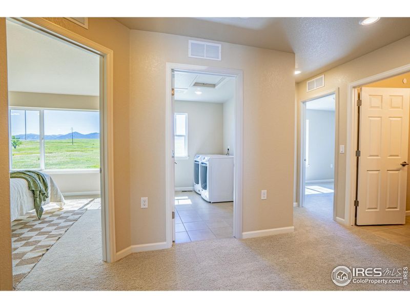 upstairs rooms surround the laundry room with a full linen closet for convenience and storage