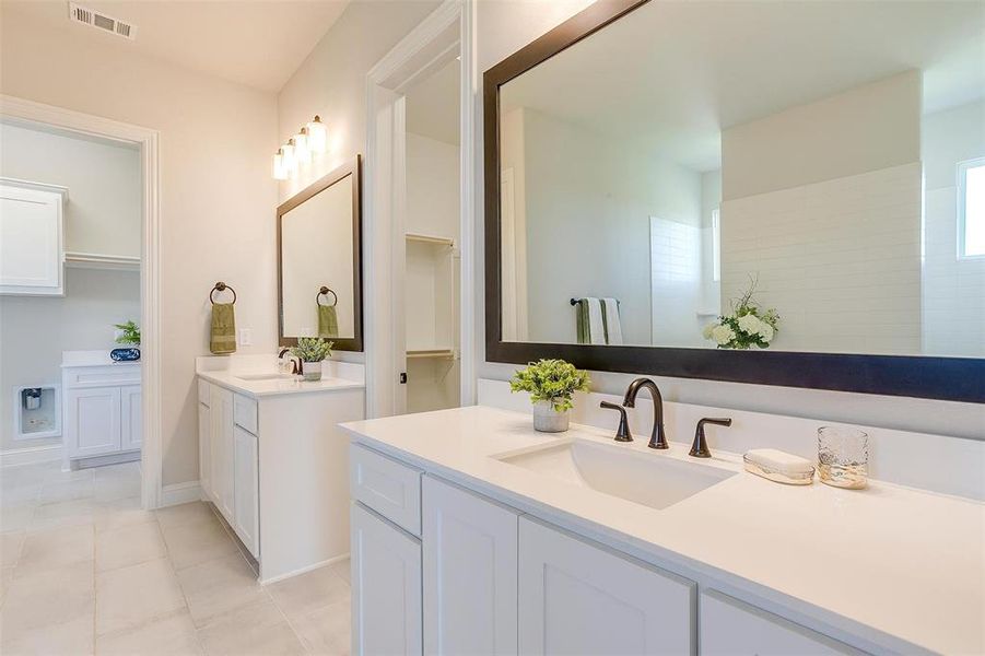 Bathroom with double sink vanity and tile patterned flooring