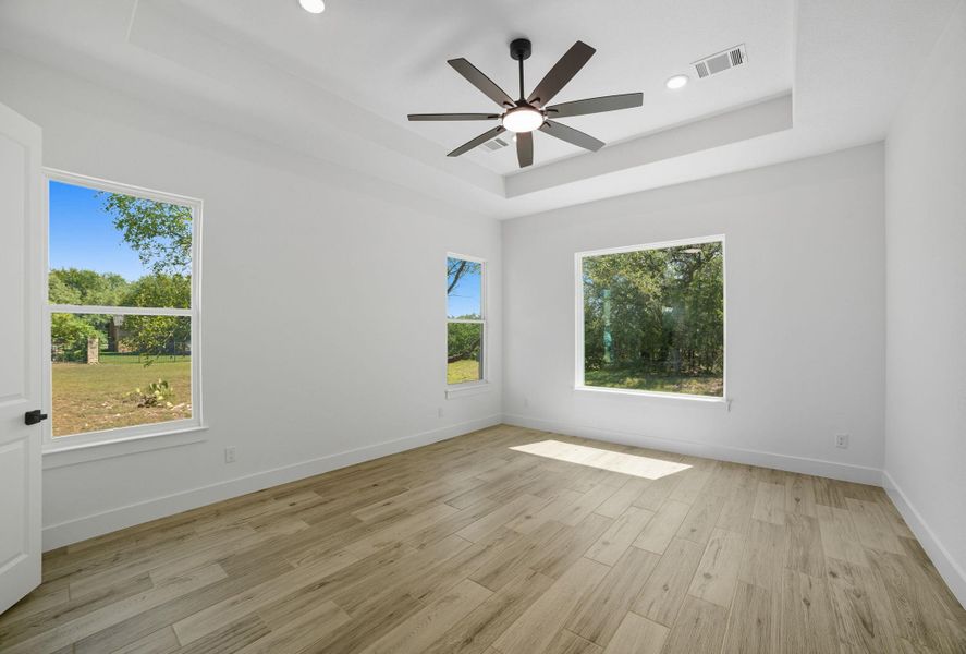 Unfurnished room featuring a tray ceiling, light wood-type flooring, ceiling fan, and recessed lighting Unfurnished room featuring a tray ceiling, light wood-type flooring, ceiling fan, and recessed lighting