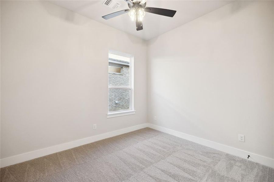 Carpeted spare room featuring ceiling fan