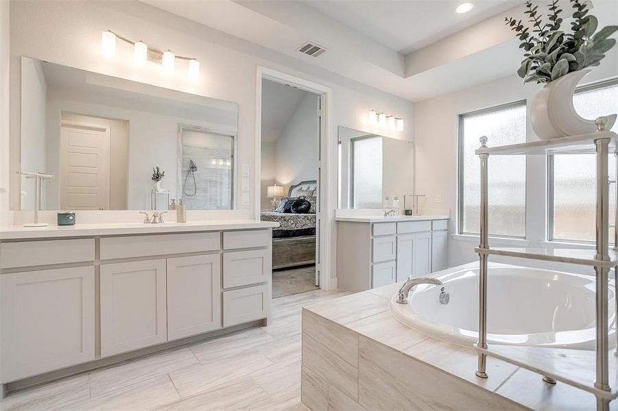 Ensuite bathroom featuring vanity, a garden tub, a walk in shower, and recessed lighting Ensuite bathroom featuring vanity, a garden tub, a walk in shower, and recessed lighting