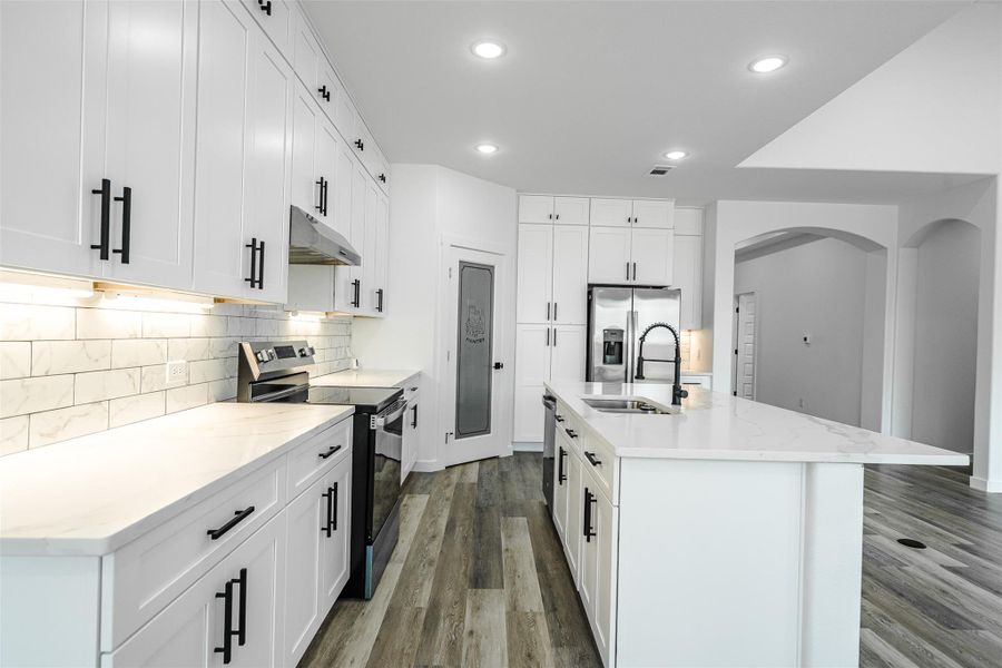 A well-appointed culinary space featuring sleek cabinetry, quartz countertops, and modern appliances. A well-appointed culinary space featuring sleek cabinetry, quartz countertops, and modern appliances.
