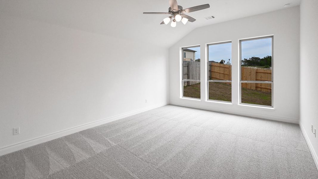 Spare room with vaulted ceiling, light colored carpet, baseboards, and ceiling fan Spare room with vaulted ceiling, light colored carpet, baseboards, and ceiling fan