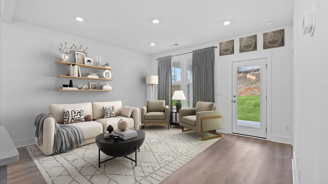 Elegant family room featuring hardwood flooring, large windows, and thoughtful architectural detail in Moore, SC