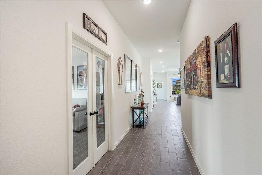 Hallway from entry leading to the French doors of a the office/study, creating a warm and stylish entrance to the home.