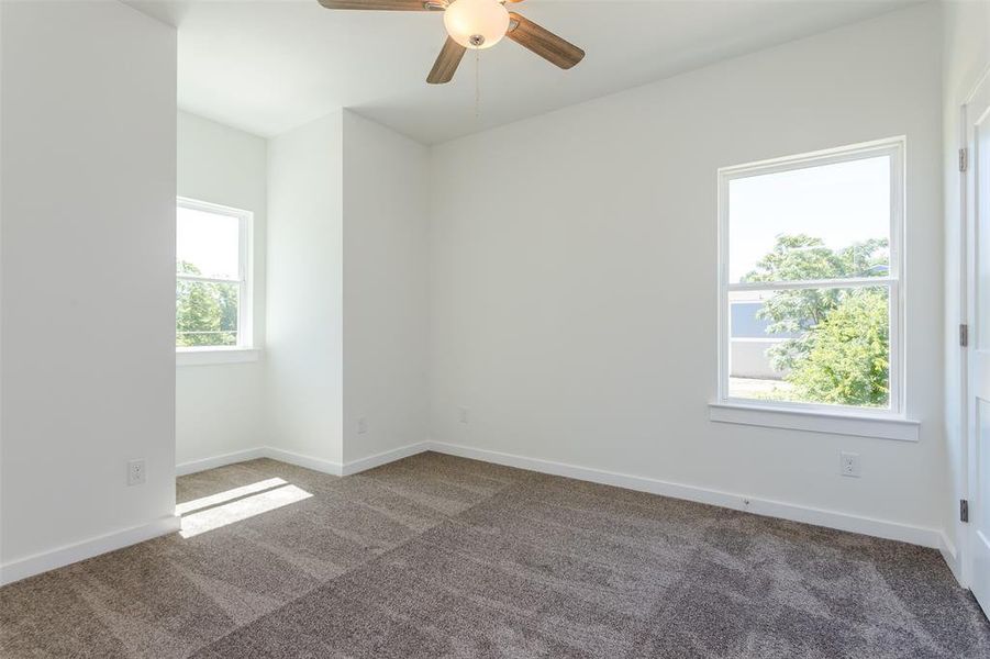 Carpeted spare room with ceiling fan