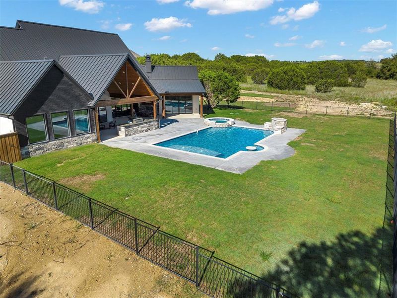 View of pool with a patio area, a yard, and an in ground hot tub