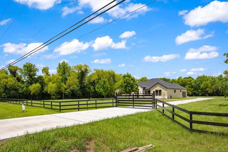This photo showcases a modern single-story home with a sleek exterior featuring an automatic gate.