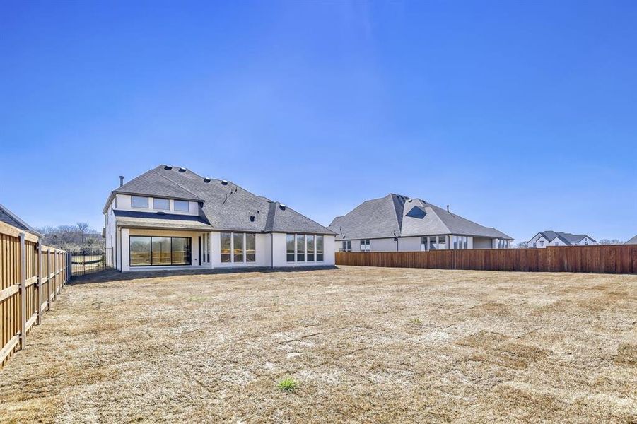 Back of property featuring a fenced backyard and a patio