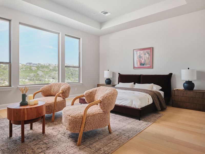 The primary suite offers a peaceful retreat with a tray ceiling and a spacious layout allowing for a sitting area.