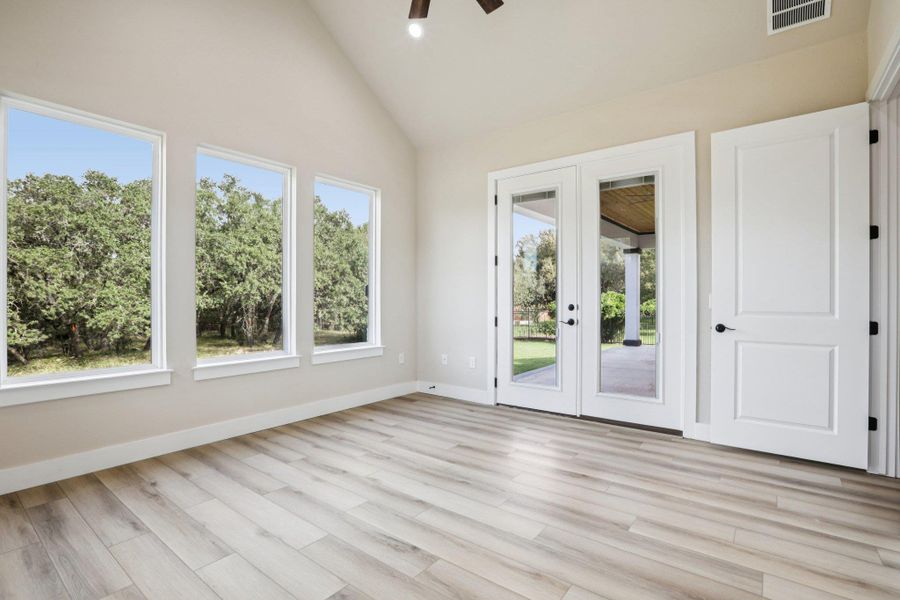 Spare room with french doors, light wood-style flooring, high vaulted ceiling, a ceiling fan, and recessed lighting