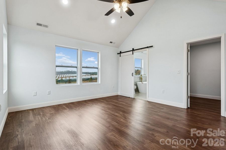 Primary bedroom on second level with cathedral ceiling, ceiling fan and recessed lighting