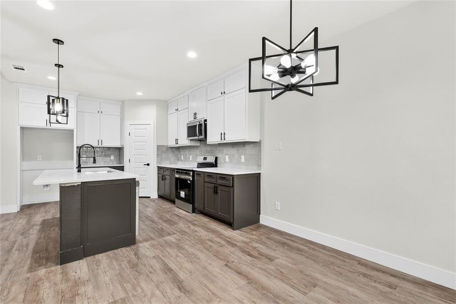 Open-concept living space featuring wood-finish flooring, a vaulted ceiling with a ceiling fan, and multiple windows