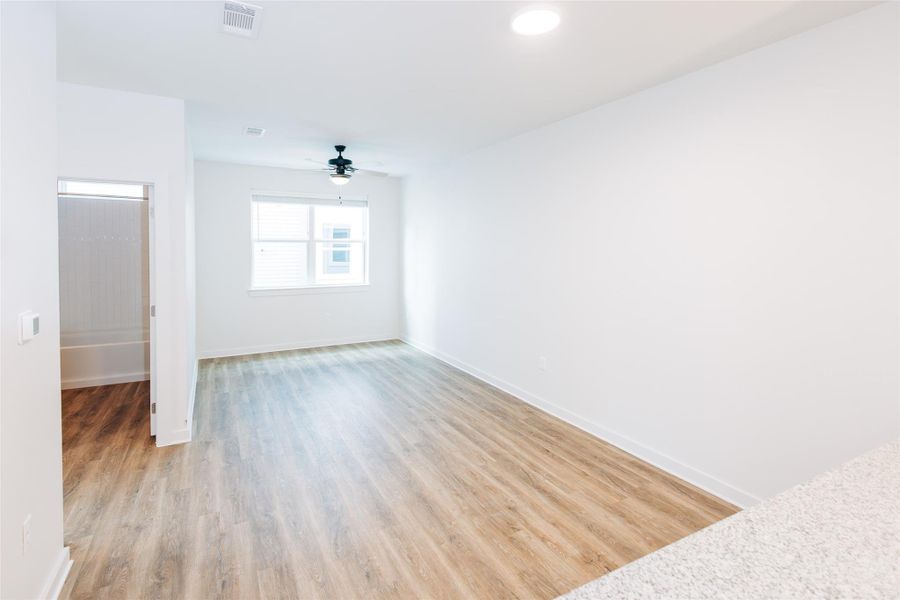 Unfurnished room with ceiling fan and light wood-type flooring