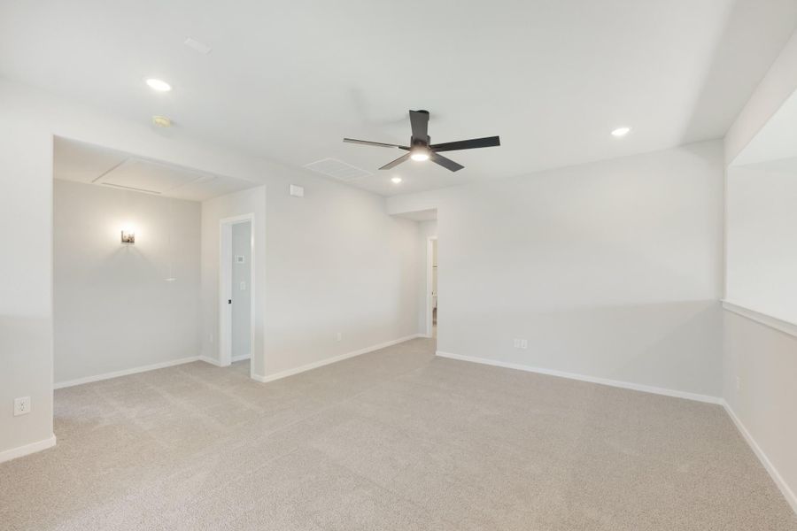 Empty bedroom with beige carpet, white walls, ceiling fan, and recessed lighting Empty bedroom with beige carpet, white walls, ceiling fan, and recessed lighting