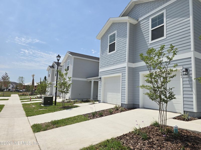 Front exterior of a new home in The District at Oakleaf - The Commons, Middleburg, FL, highlighting curb appeal (Image 18).