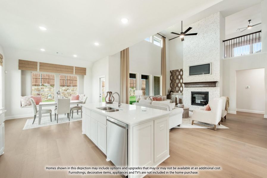Open-concept kitchen and living area with white island, stone fireplace, and high vaulted ceiling Open-concept kitchen and living area with white island, stone fireplace, and high vaulted ceiling