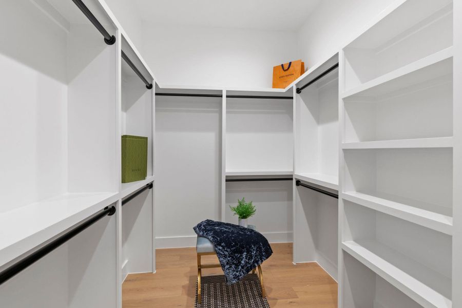Walk in closet with light wood-style flooring