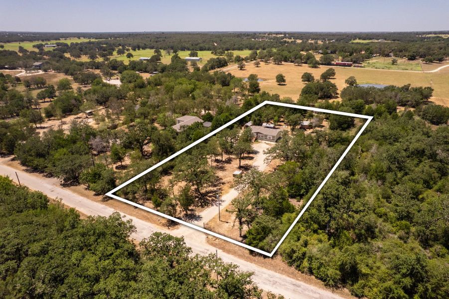 Mature trees surround this peaceful country property outlined by spacious acreage.