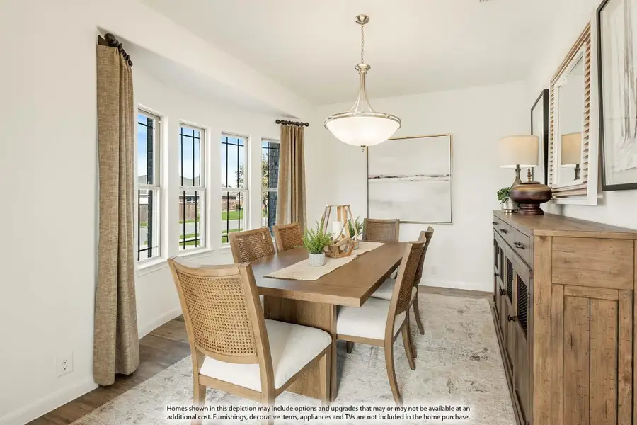 Dining room with wooden table, cane-back chairs, pendant light, and wood sideboard near large windows
