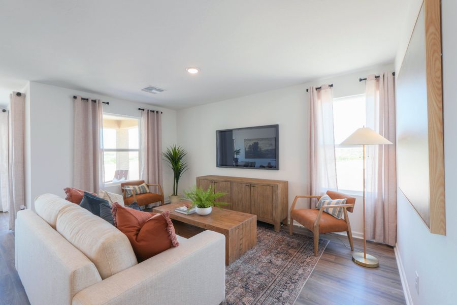 A living room with a tv and couches. A living room with a tv and couches.