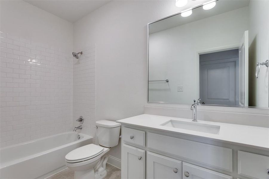 Full bathroom featuring toilet, vanity, and tiled shower / bath