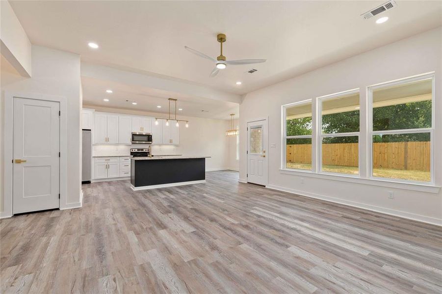 Unfurnished living room with recessed lighting, ceiling fan, and light wood finished floors Unfurnished living room with recessed lighting, ceiling fan, and light wood finished floors