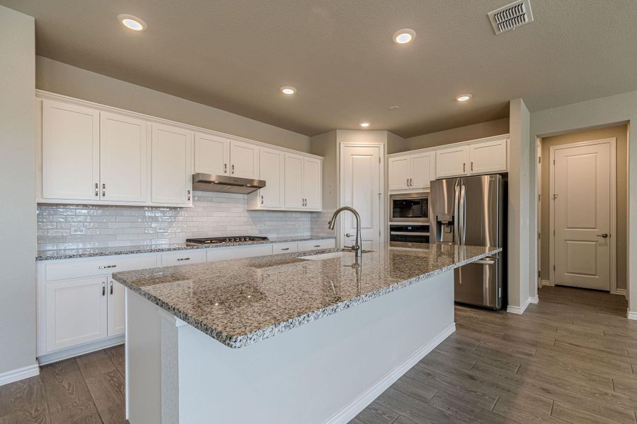 Kitchen featuring white cabinets, appliances with stainless steel finishes, light stone counters, decorative backsplash, and recessed lighting Kitchen featuring white cabinets, appliances with stainless steel finishes, light stone counters, decorative backsplash, and recessed lighting