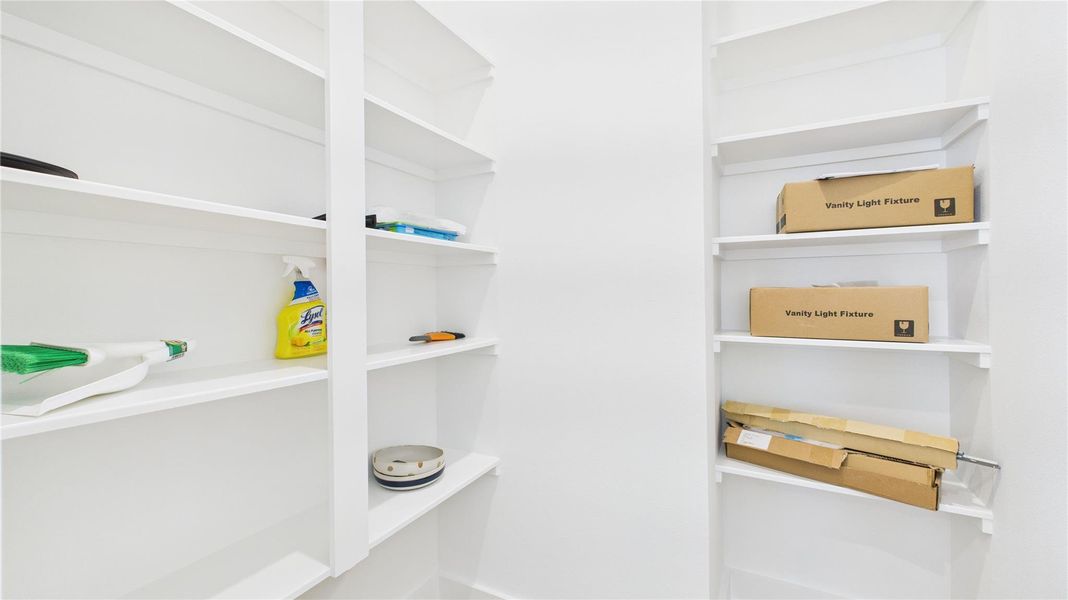 This spacious walk-in pantry offers ample shelving and storage, keeping the kitchen organized and functional while providing easy access for everyday cooking and entertaining needs.