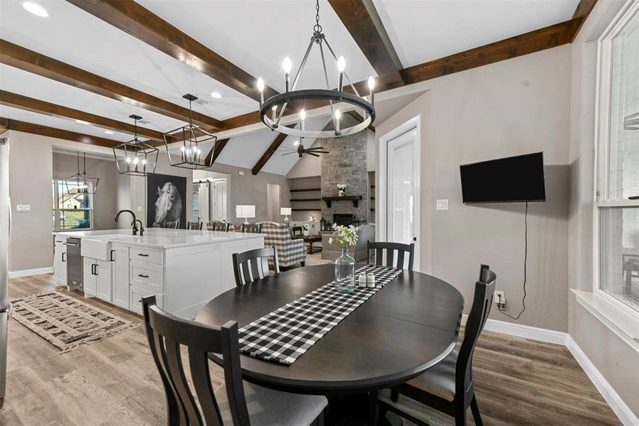 Dining space with a fireplace, sink, hardwood / wood-style floors, and ceiling fan with notable chandelier