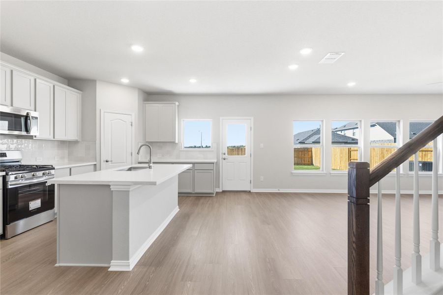 Kitchen with stainless steel appliances, decorative backsplash, healthy amount of natural light, recessed lighting, and light wood finished floors