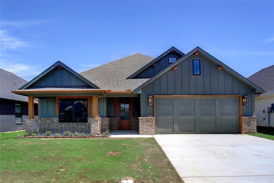 View of front of house with a garage and a front yard