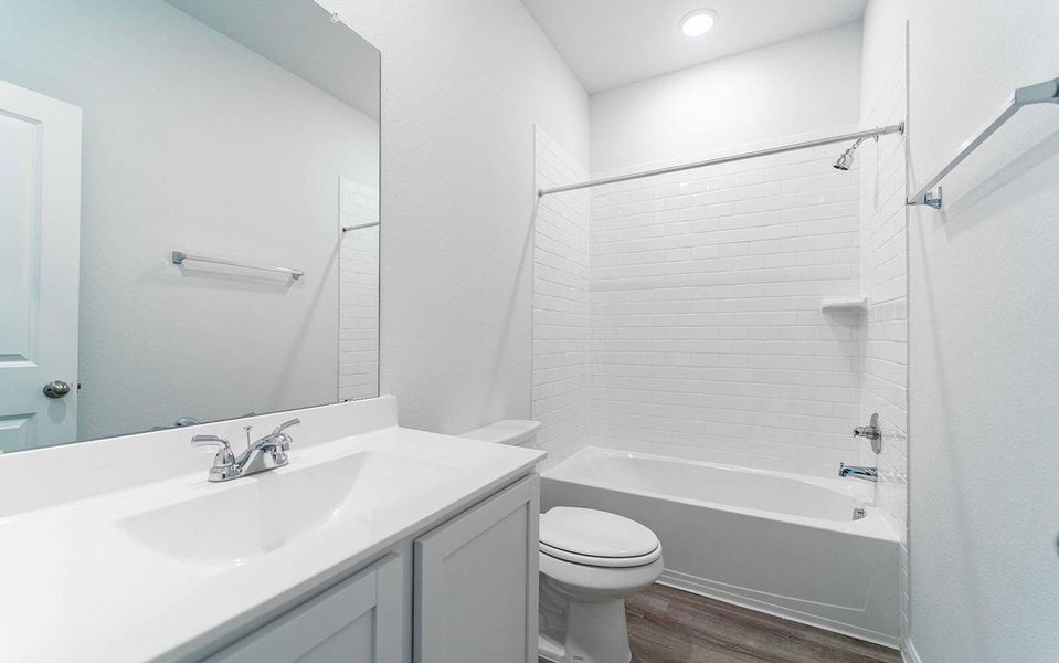 Bathroom with shower combination, vanity, and dark wood-type flooring Bathroom with shower combination, vanity, and dark wood-type flooring