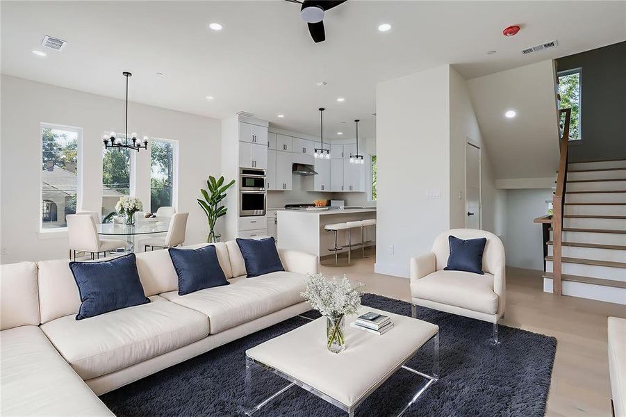 Living area featuring recessed lighting, plenty of natural light, stairs, and a chandelier
