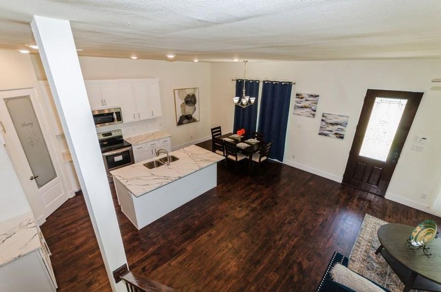 Kitchen featuring sink, dark hardwood / wood-style floors, appliances with stainless steel finishes, and white cabinetry